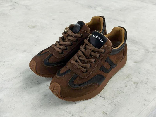 zapatillas de moda de la marca Yokono, para mujer, con estilo retro running vintage, en piel ante color marrón y detalles en negro, con cordones, logo de la marca en las lengüetas, suela dentada y detalles de goma en puntera y talonera.