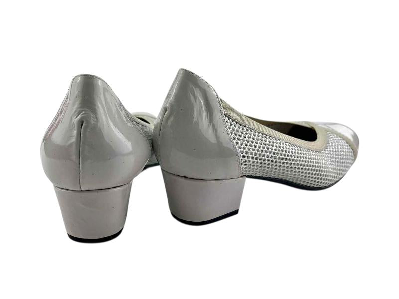 Zapatos de la marca Cutillas en color plata con talonera en charol, tacón cuadrado bajo y malla elástica.
