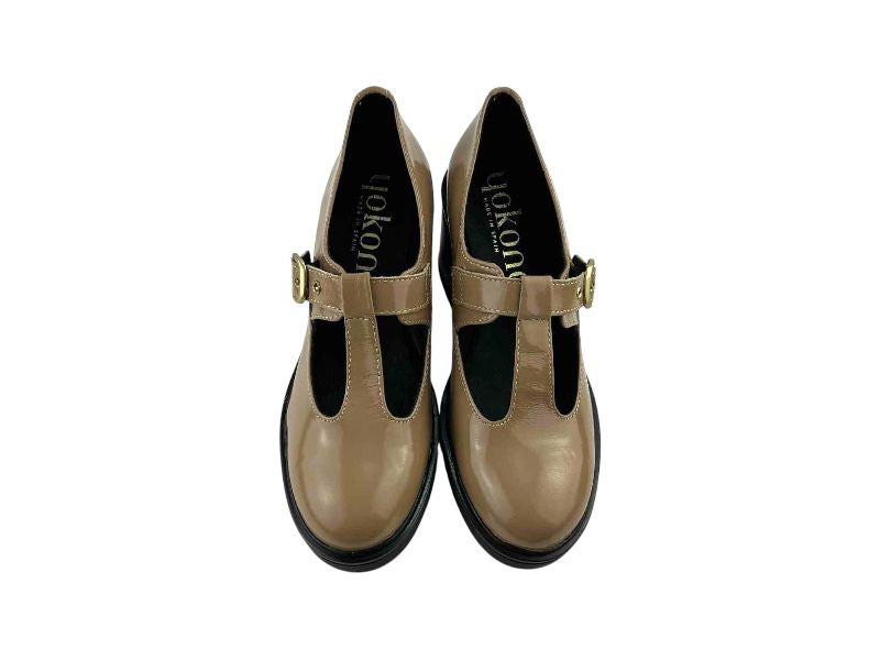 Zapatos artesanos de mujer de la marca española Yokono, estilo merceditas, tira en T en el empeine, hebillas doradas, plataforma y tacón cuadrado en color negro.