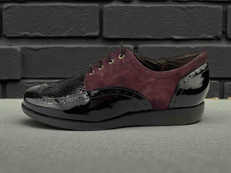 Zapatos Oxford de mujer en piel ante y charol color burdeos,con textura de serpiente y detalles brogue.