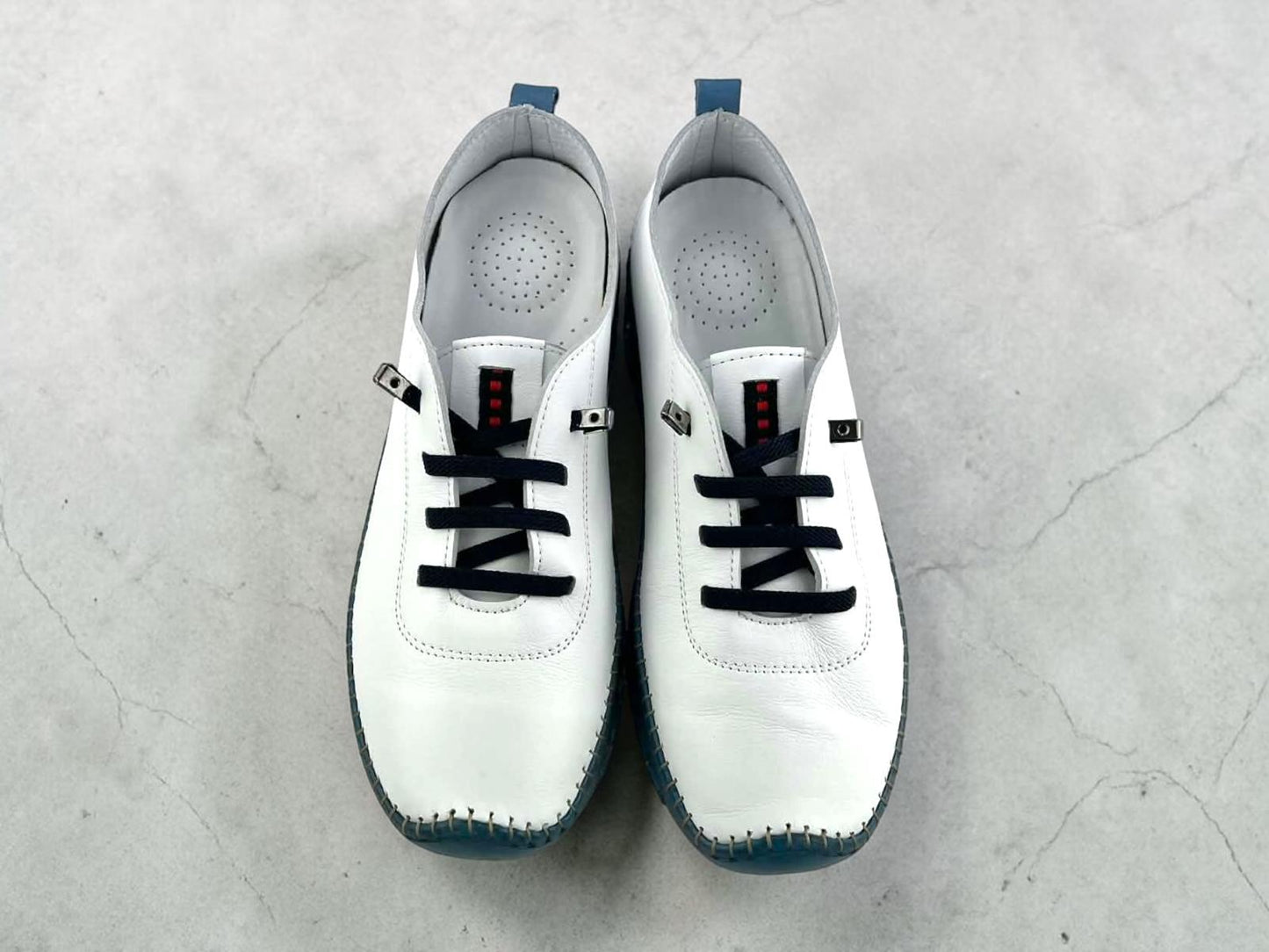 Zapatos  para mujer de piel blanca con suela flexible y cordones elelásticos. Diseño ergonómico, transpirable y artesanal. Comodidad y estilo casual para tu día a día.