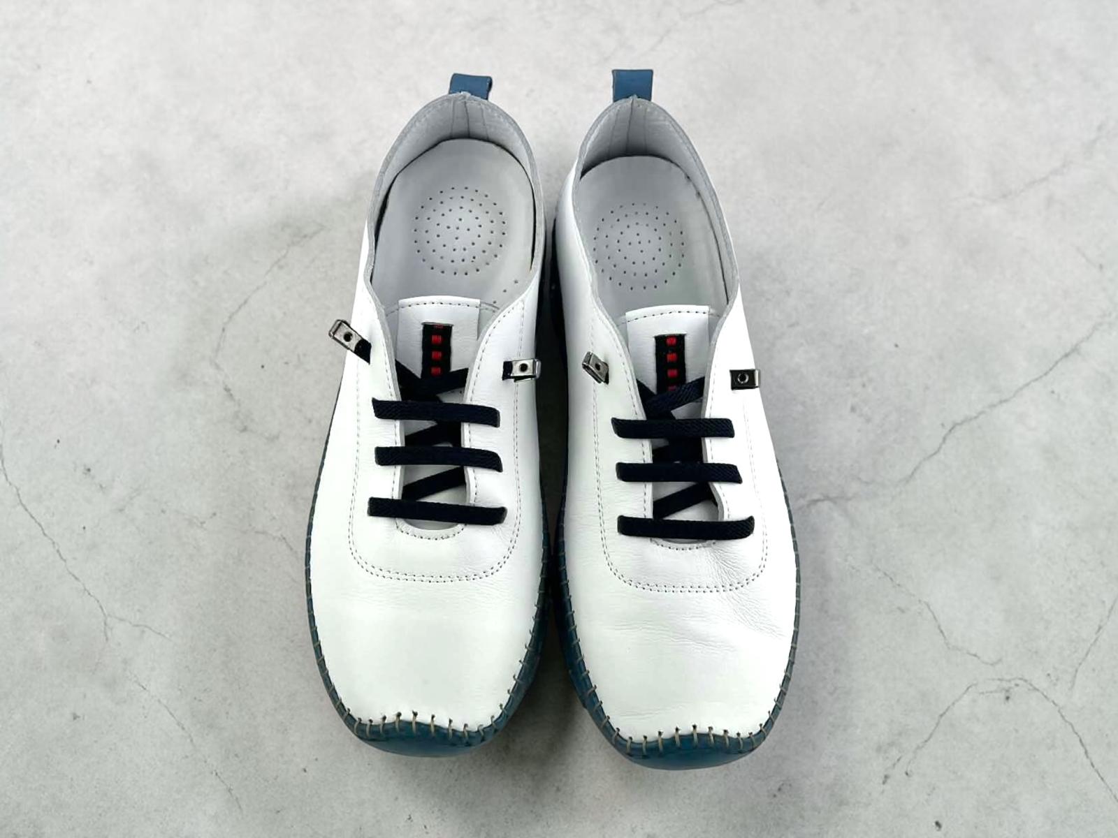 Zapatos  para mujer de piel blanca con suela flexible y cordones elelásticos. Diseño ergonómico, transpirable y artesanal. Comodidad y estilo casual para tu día a día.
